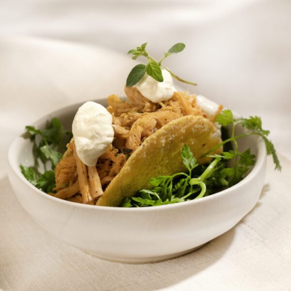 Mini taco de pernil desfiado com sour cream