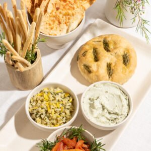 Seleção de pães de fermentação natural (focaccia de alecrim, pão placa de parmesão e grissinis)