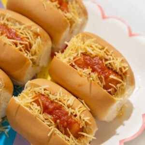 Mini hotdog com molho de tomates frescos e batata palha